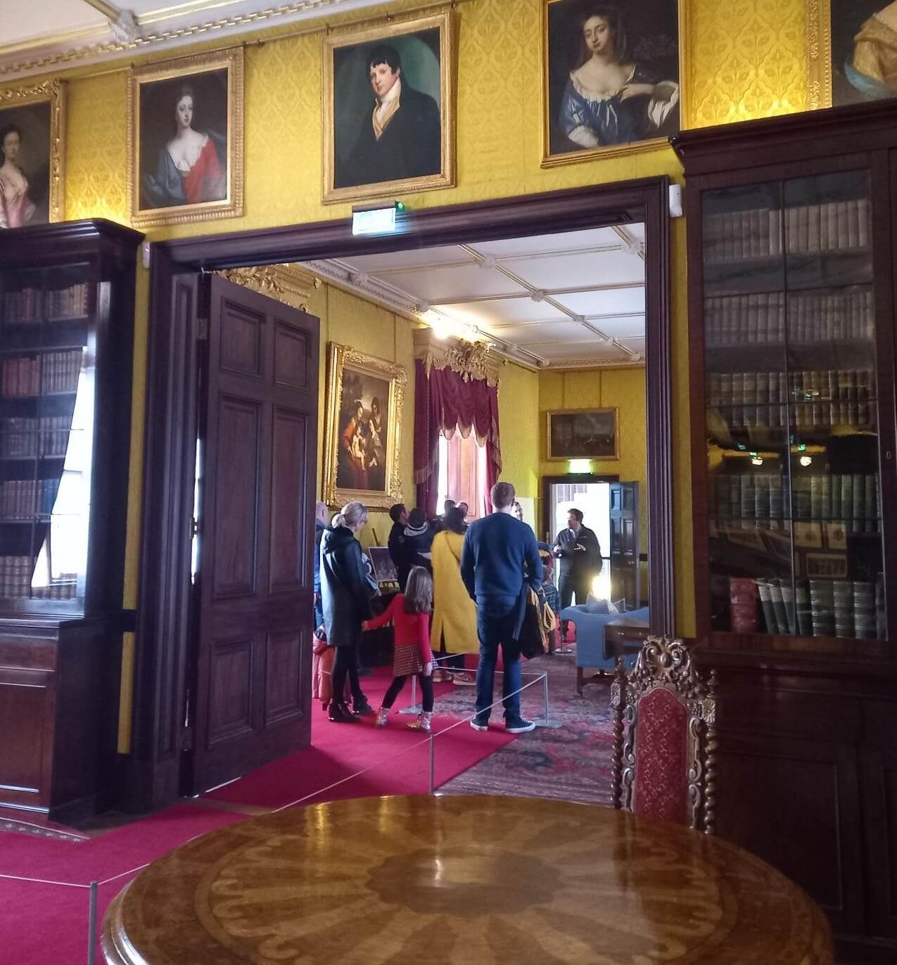 A guide guiding a guided tour to a small group of adults and children in the Drawing Room